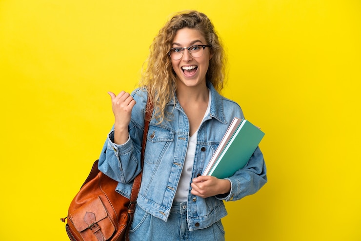 Photo young student caucasian woman isolated on yellow background pointing to the side to present a product
