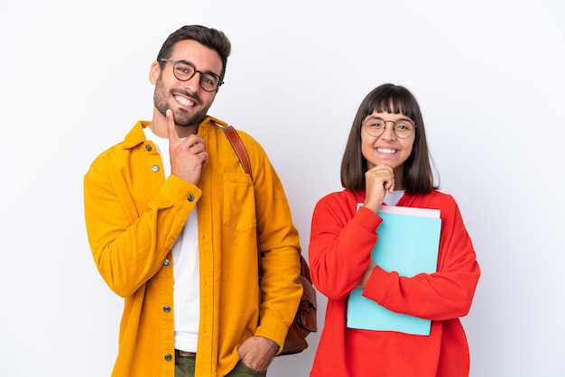 Coppia giovane studente isolato su sfondo bianco sorridente con un'espressione dolce