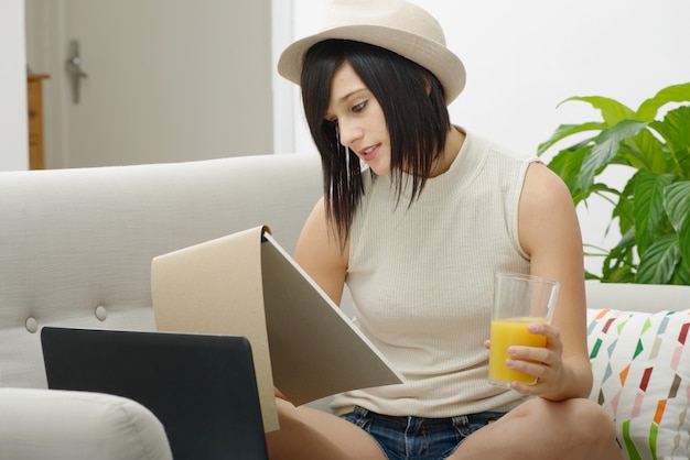 Young student drinking orange juice in couch