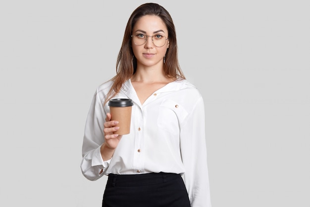 Young student in formal clothes, holds takeaway coffee