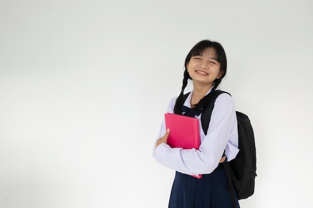 Молодая студентка держит розовую книгу на белом фоне