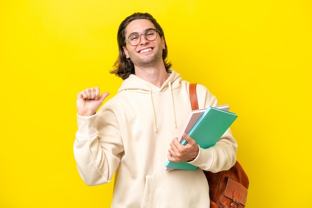 Foto giovane studente bell'uomo isolato su sfondo giallo orgoglioso e soddisfatto