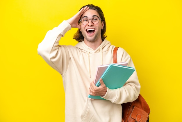 Young student handsome man isolated on yellow background with surprise expression