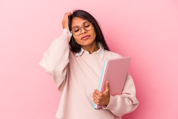 Giovane studentessa latina isolata su sfondo rosa scioccata, ha ricordato un incontro importante.