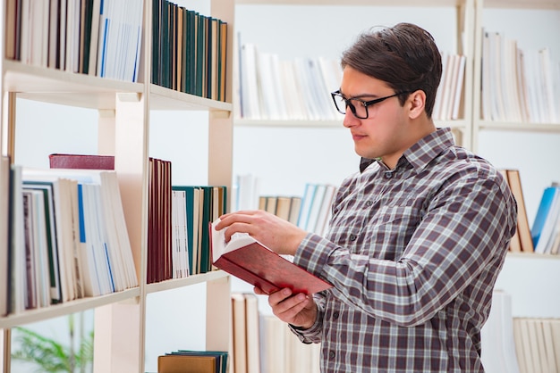 Young student looking for books in college library