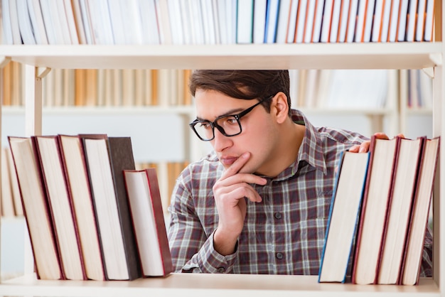 Young student looking for books in college library