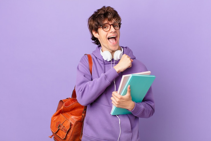 Photo young student man feeling happy and facing a challenge or celebrating