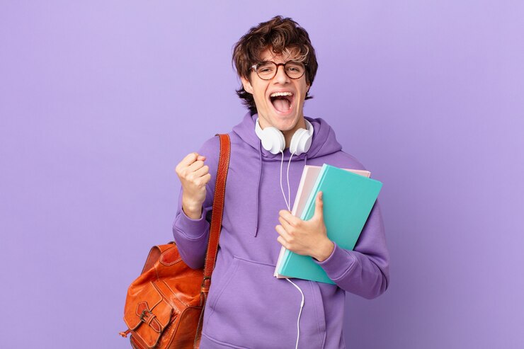 Photo young student man feeling shocked,laughing and celebrating success