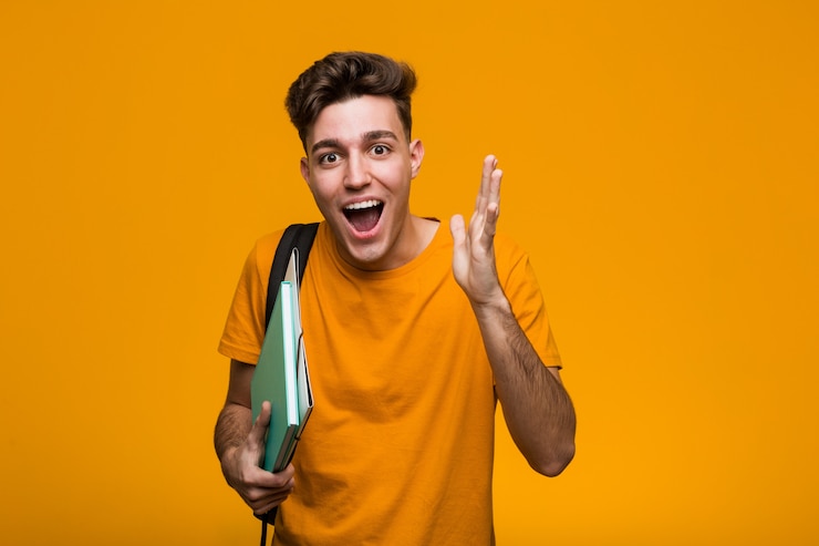 Photo young student man holding books happy, smiling and cheerful.