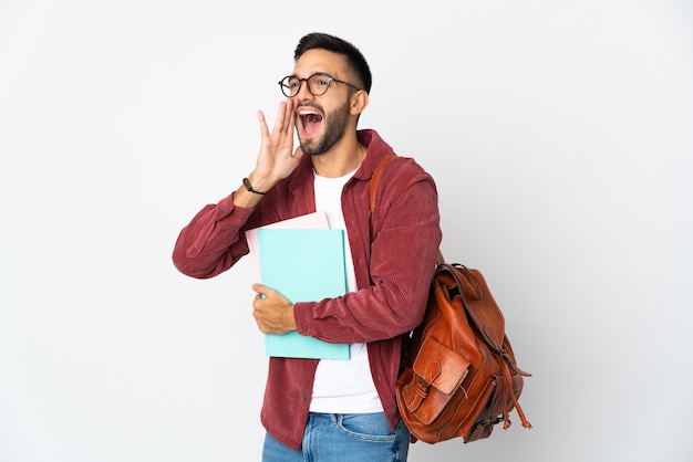 Giovane studente uomo isolato gridando con la bocca spalancata di lato