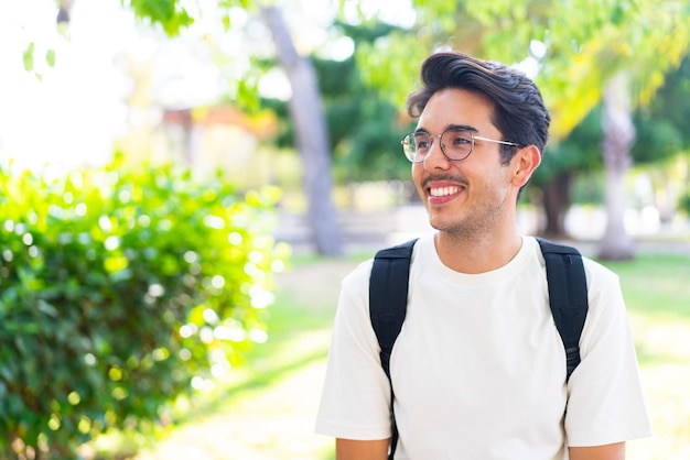 幸せな表情で屋外で若い学生男