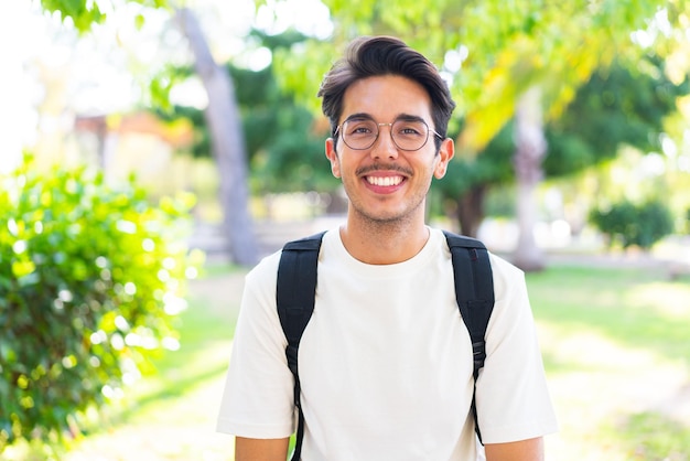 Young student man at outdoors with happy expression