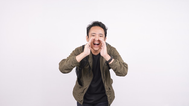 Young student man wearing a bag shouting and yelling isolated on white backgroud