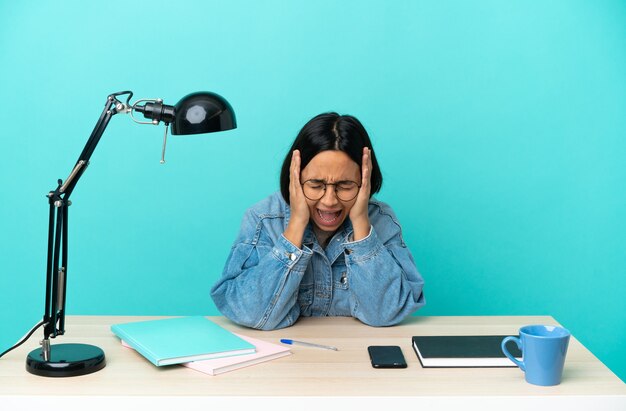 Young student mixed race woman studying on a table stressed overwhelmed