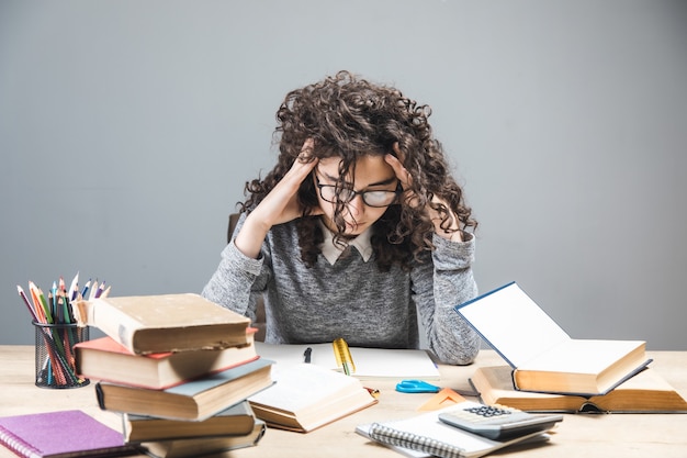 Young student prepares for lessons on table