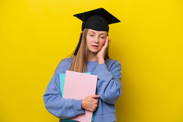 Young student Russian woman isolated on yellow background with headache