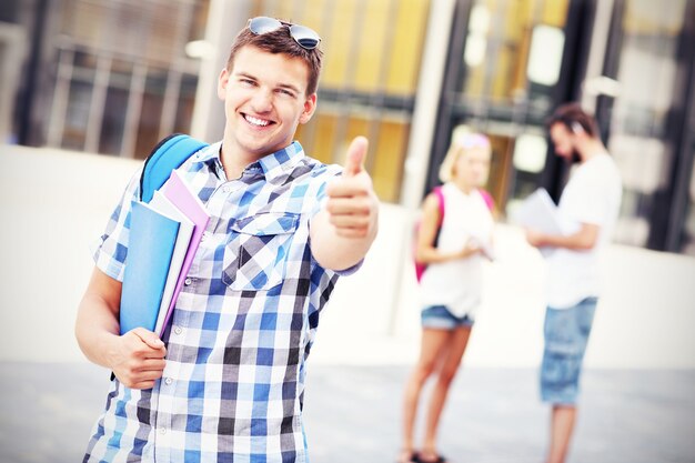 a young student showing ok sign in the campus