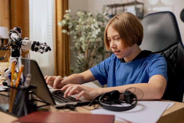 Young student sits at desk in front of laptop clicks fingers on keyboard prepares software