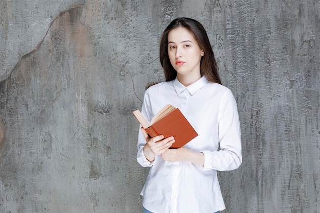 Young student or teacher with open book standing and posing. High quality photo