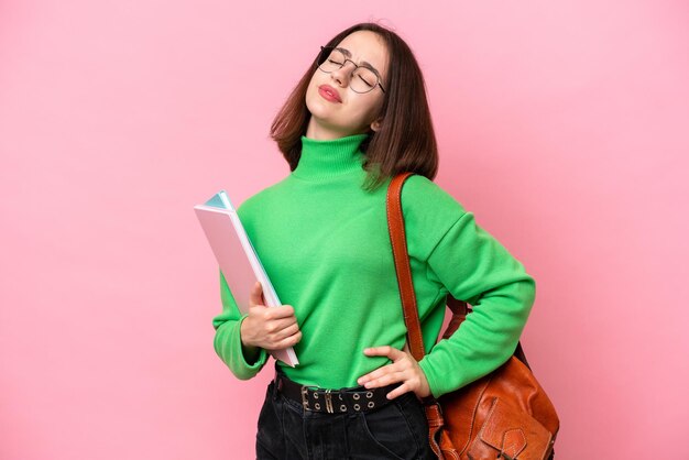 Young student Ukrainian woman isolated on pink background suffering from backache for having made an effort