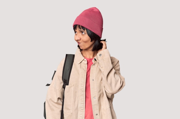 Photo young student with backpack and beanie in studio shouting and holding palm near opened mouth