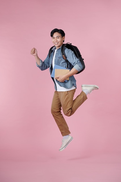 Young student with book on pink