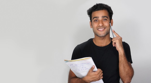 A Young Student With Books and pen Isolated wall - Education Concept