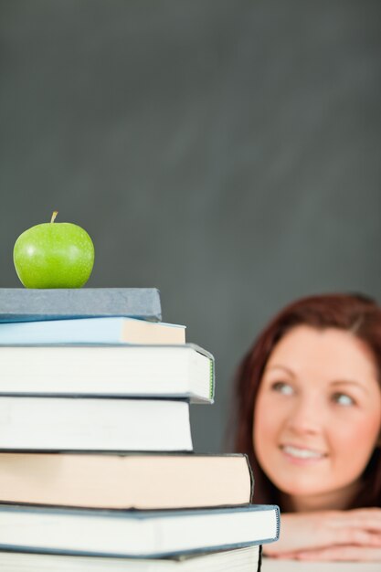 Young student with a stack of books and an apple