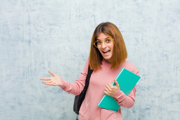 Young student woman feeling happy, astonished, lucky and surprised, like saying omg seriously? Unbelievable