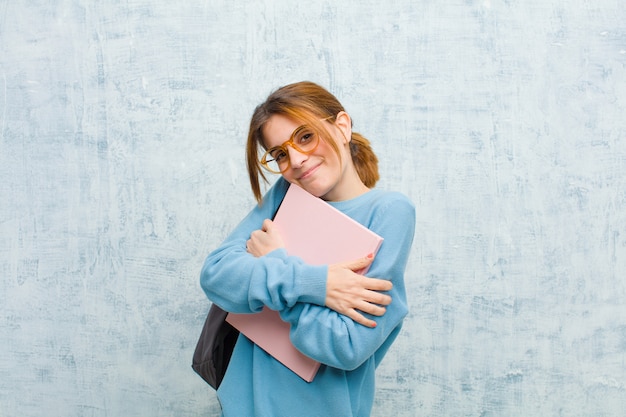 Photo young student woman feeling in love, smiling, cuddling and hugging self, staying single, being selfish and egocentric  grunge wall