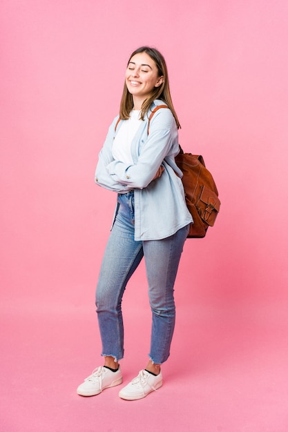 Young student woman going to school isolated on pink background