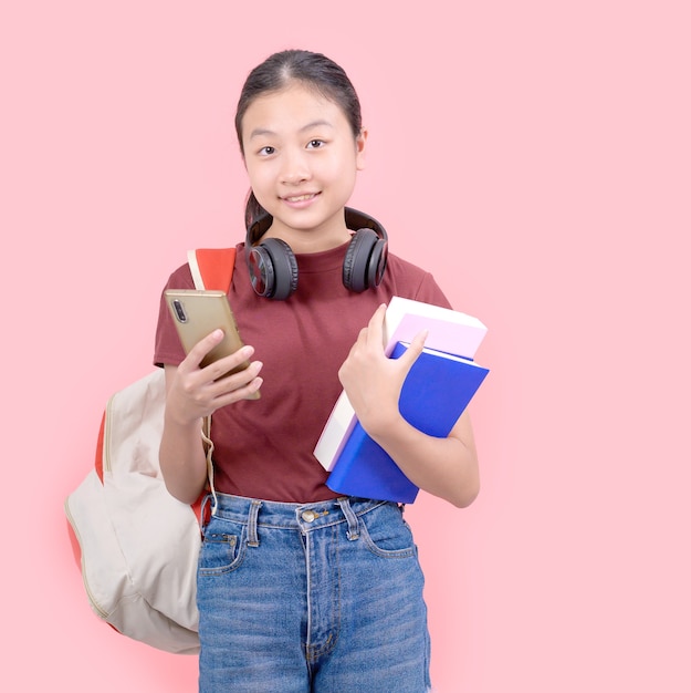 Young student woman in high school smiling at the camera pink wall