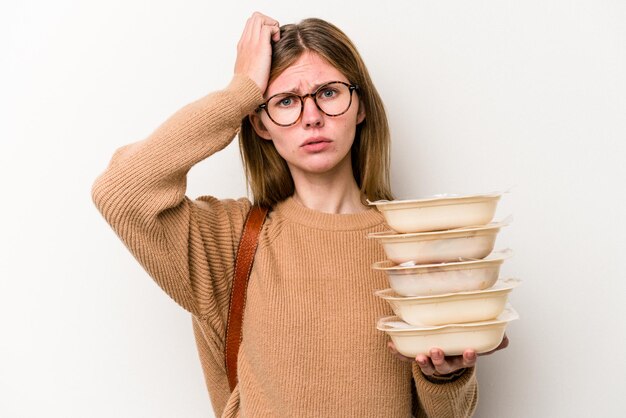 Young student woman holding a toppers isolated on white background being shocked, she has remembered important meeting.