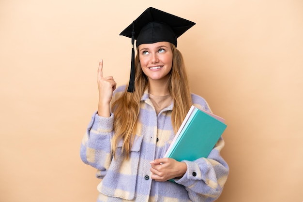 Young student woman over isolated background pointing up a great idea