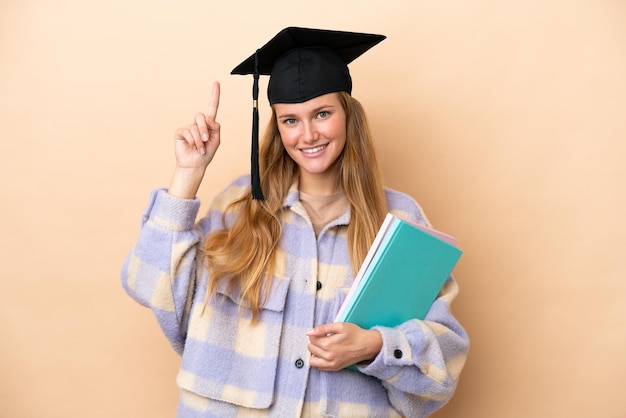 Young student woman over isolated background pointing up a great idea