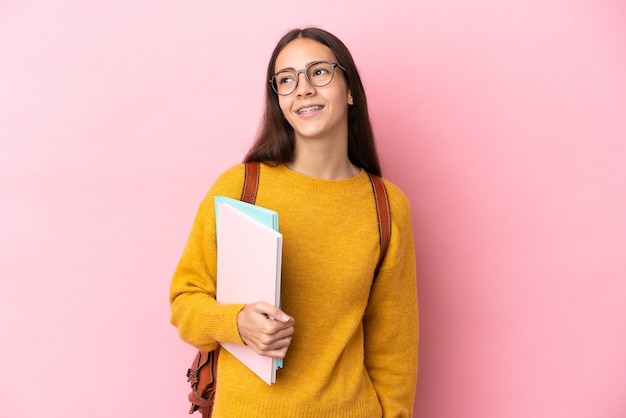 La giovane donna dello studente ha isolato il fondo che pensa un'idea mentre guarda in su