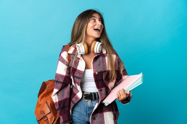 Young student woman isolated on blue laughing