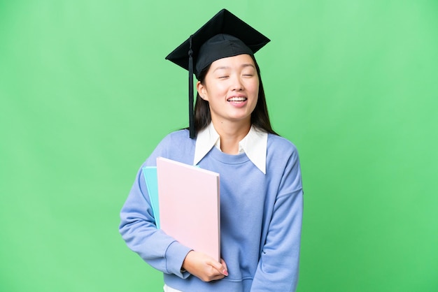 孤立したクロマ キーの背景の上に笑いながら若い学生女性