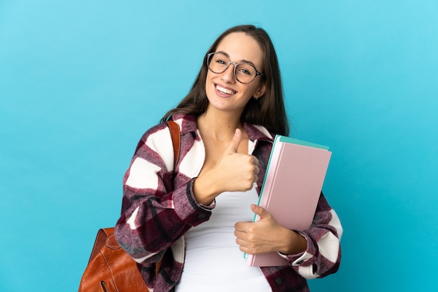 Young student woman over isolated giving a thumbs up gesture