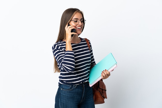 Young student woman isolated keeping a conversation with the mobile phone