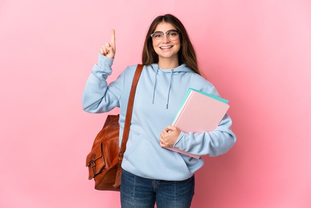 Young student woman isolated on pink wall pointing up a great idea