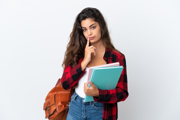 Young student woman isolated on white background having doubts while looking up