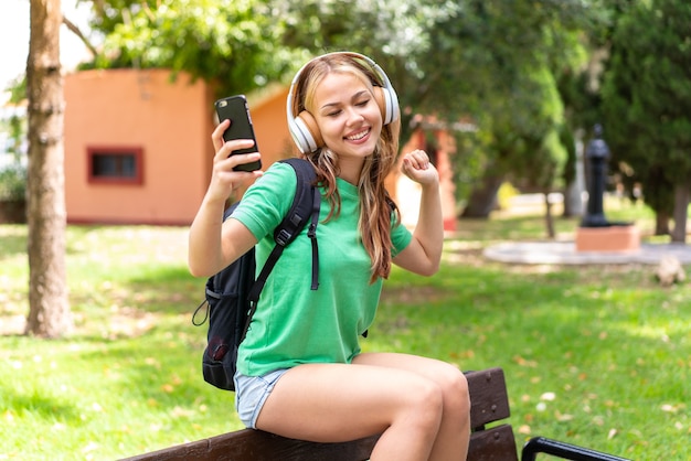 携帯電話を使用して屋外で若い学生女性