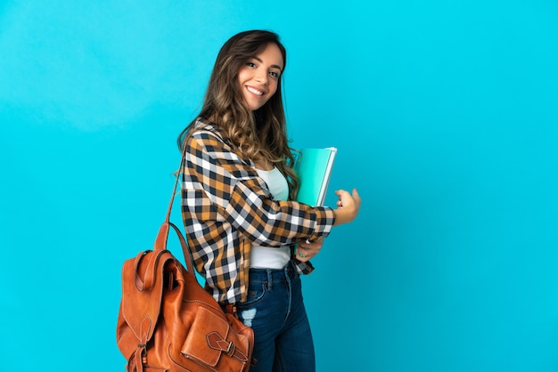 Young student woman posing isolated against the blank wall