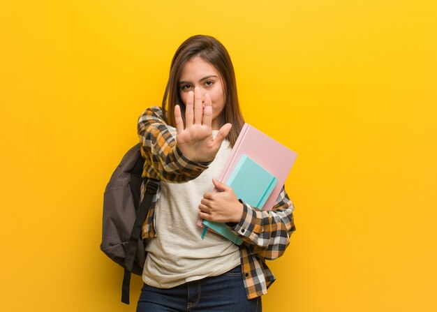 Young student woman putting hand in front