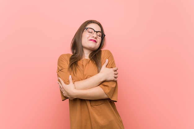 Young student woman wearing eyeglasses hugs, smiling carefree and happy.