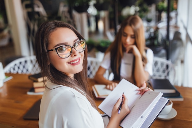 Young student working in the office with her collegue