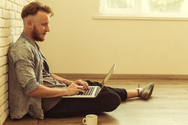 Young student works on his laptop at home