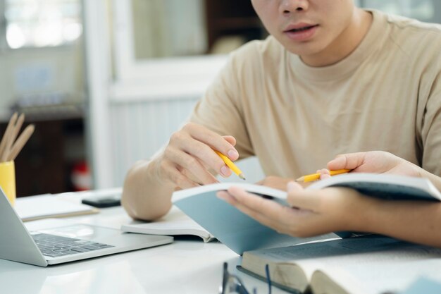 写真 若い学生のキャンパスは、友人が追いついて学習するのを助けます