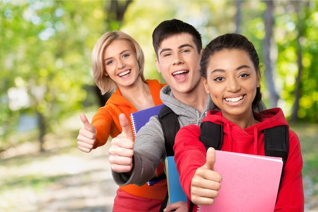 Young students gesturing thumbs up on background